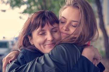 April 25, International Daughter's Day, Mother's Day, happy family, mother and daughter cuddle tenderly, natural feelings