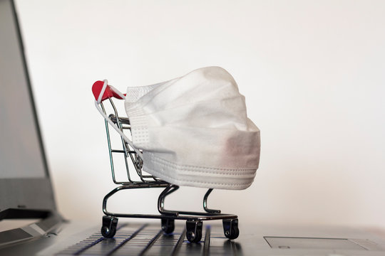 Shopping Cart With Medical Face Mask On Laptop Computer