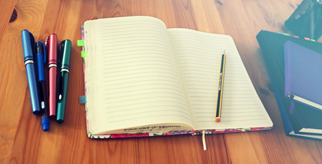 stationery materials and tools for study and business  with many pens of colors and an open blank...
