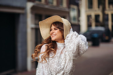 Close-up portrait of a beautiful woman in a vintage summer hat. A beautiful woman in a boho straw hat and dress.