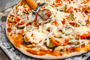 Italian pizza with bacon and pickles, mushrooms, capers and Parmesan cheese. Side view, top view. On a light table. Space for text