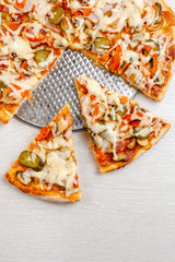 Italian pizza with bacon and pickles, mushrooms, capers and Parmesan cheese. Side view, top view. On a light table. Space for text