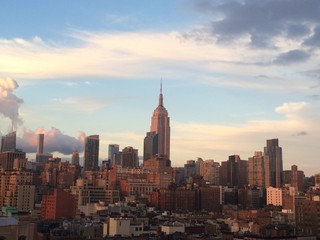 Fototapeta na wymiar Empire State Building In City Against Cloudy Sky