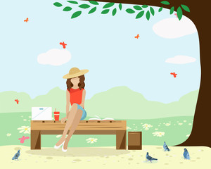 A girl is sitting on a Park bench with a laptop and a book