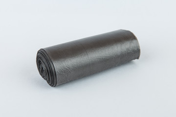 Black plastic polyethylene garbage bags roll isolated over the white background.