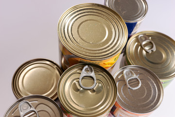 Various canned food in metal cans, top view. Canned goods non perishable food storage goods