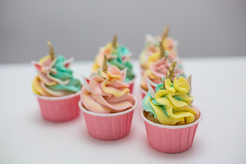 colored cupcakes on a white wooden table