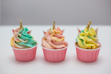colored cupcakes on a white wooden table