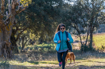 young girl in blue sportswear running and playing sports in nature