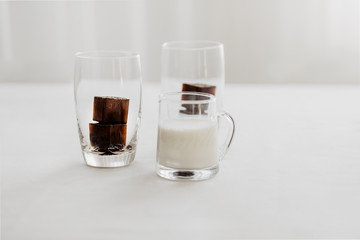 Frozen coffee ice cubes in a glass with milk to make a refreshing summer iced coffee drink. White background, isolated, copy space.