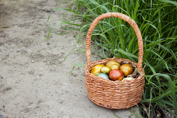 Easter colored eggs in a basket in the grass.Bright family holiday of Easter