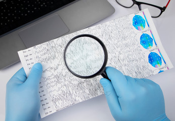 A neurologist examines an encephalogram of a patient’s brain. Schedule of electroencephalograms - study of brain currents for signs of epilepsy and pathologies of the nervous system