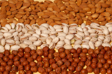 Assorted nuts of different types lie on the table. View from above.