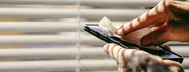 woman hands cleaning smartphone  sanitizing  coronavirus prevention