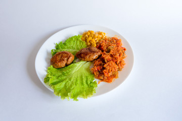 Fried chicken cutlet with potato slices served with tomato cherry and corn salad. Traditional belorussian food - roasted minced meat and potato