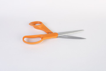 orange and silver scissors on white back ground