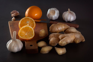 Ginger, garlic and lemon - a means to protect against viral infection and colds on a dark table. Low key