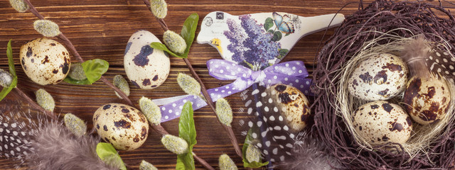 Easter holiday background, postcard - easter eggs in a nest with spring branches of willow and decor, top view