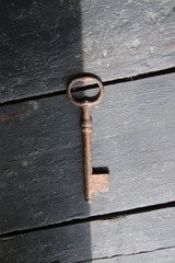 Choice concept. Old vintage key on a  wooden background.