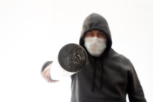 Aggressive man in hoodie pokes in face with baseball bat