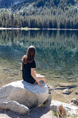 girls sitting on stone at lake in yosemite park