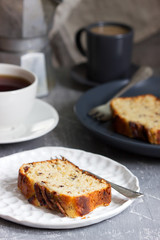 Banana muffin with candied ginger and raisins and drinks on a gray background.
