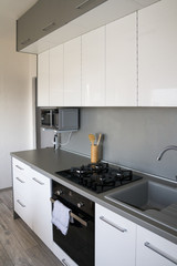 Scandinavian, Minimalism Home. White Kitchen Design. 
Modern white shiny kitchen with the silver accent and accessories. Cozy, beautiful, functional kitchen design.