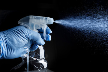 mano con vaporizzatore che spruzza un detersivo liquido isolato su sfondo nero