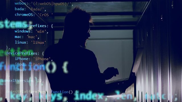 Computer code is emerging above the technician operating the laptop