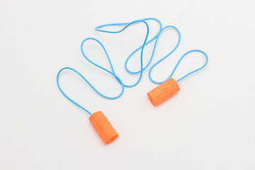 disposable orange ear plugs on a white background