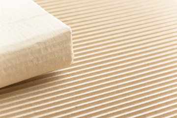 Carton or cardboard packing material. Texture of corrugated paper sheets made from cellulose. Supplies for creating boxes and packaging. Pasteboard background. Natural brown cardboard surface.