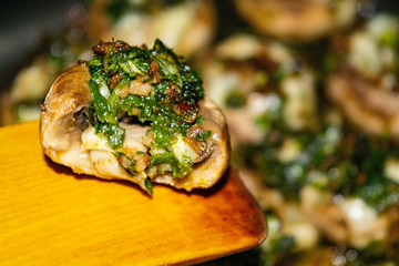 Mushrooms baked in the oven with cheese, green onions and dill. Close up.