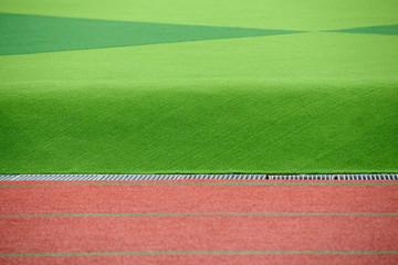 The red track and green lawn are very   beautiful