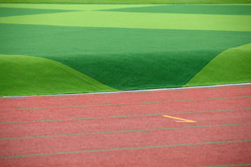 The red track and green lawn are very   beautiful
