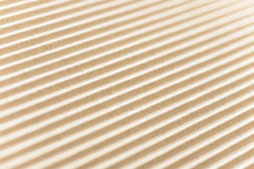 Carton or cardboard packing material. Texture of corrugated paper sheets made from cellulose. Supplies for creating boxes and packaging. Pasteboard background. Natural brown cardboard surface.