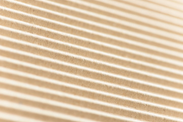 Fototapeta premium Carton or cardboard packing material. Texture of corrugated paper sheets made from cellulose. Supplies for creating boxes and packaging. Pasteboard background. Natural brown cardboard surface.