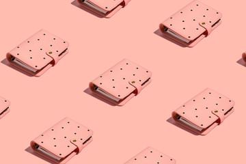 Isolated on pink a female organizer book notepad notebook in black dot print pattern