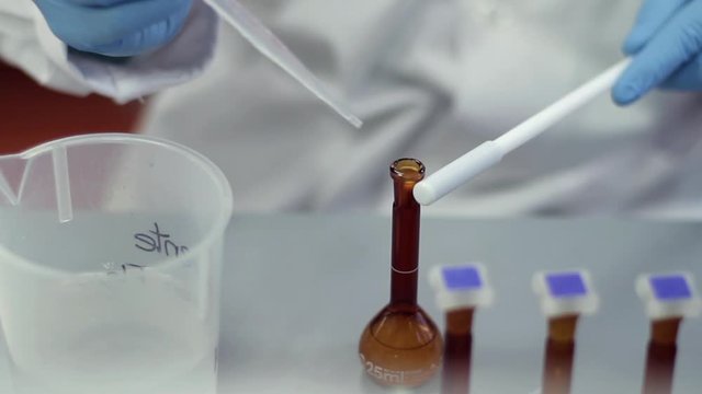 Scientist working with chemical reaction in chemistry lab. Chemical reaction in glass flask. Lab worker doing chemical experiment in laboratory