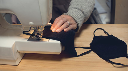 A person using the sewing machine to make masks. Masks : do it yourself. Do masks at home.