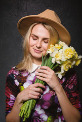 woman in dress with a bouquet of daffodils in hands