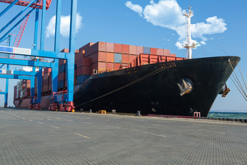 Container ship in port at container terminal. Ships of container ships stand in terminal of port on...