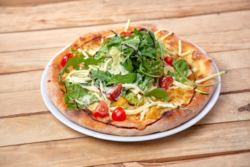 pizza with fresh vegetables on the wooden background