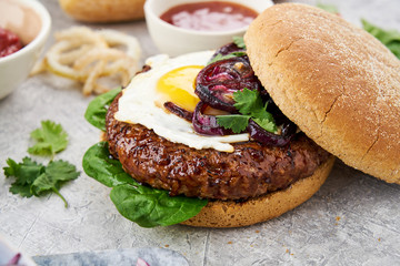 Close up of a hamburger with an egg and onions