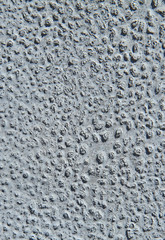 Metallic wall background, texture. Grey uneven surface with an abstract pattern of the remains of old paint. Abstract mosaic pattern on the painted surface. The wall colors. Vertical frame