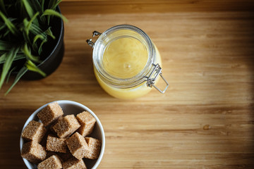 Wooden tray with tea cup and honey in a glass, cozy morning composition