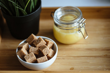 Wooden tray with tea cup and honey in a glass, cozy morning composition