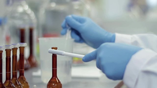 Scientist working with chemical reaction in chemistry lab. Chemical reaction in glass flask. Lab worker doing chemical experiment in laboratory