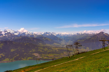 Panorama of Lake Thun and Bernese Alps including Jungfrau, Niesen, Eiger and Monch peaks from the top of Niederhorn in summer, Canton of Bern, Switzerland.