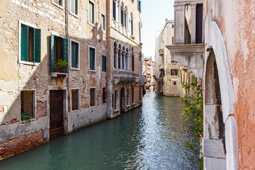 Water channels of Venice city. Facades of residential buildings overlooking the small canal in Venice, Italy.
