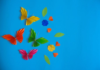 Fototapeta na wymiar Origami multicolored butterflies on a blue background